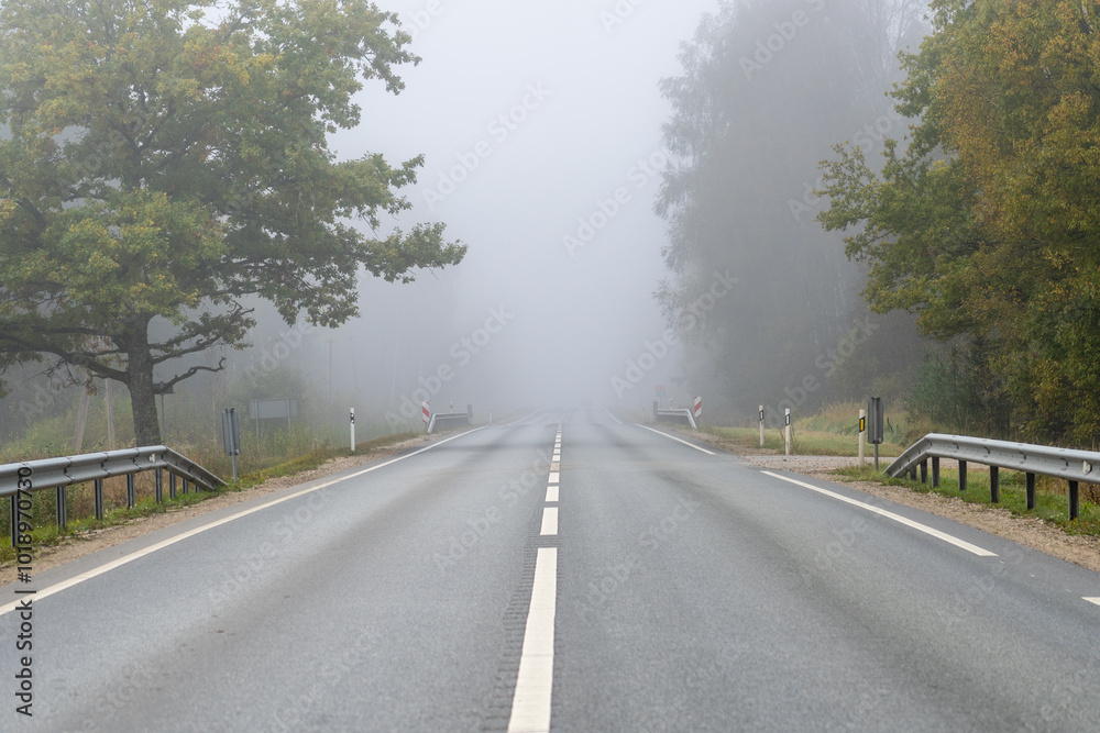 Fototapeta premium Asphalted road covered in fog