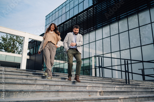 Business people walking down stairs in front of office building photo