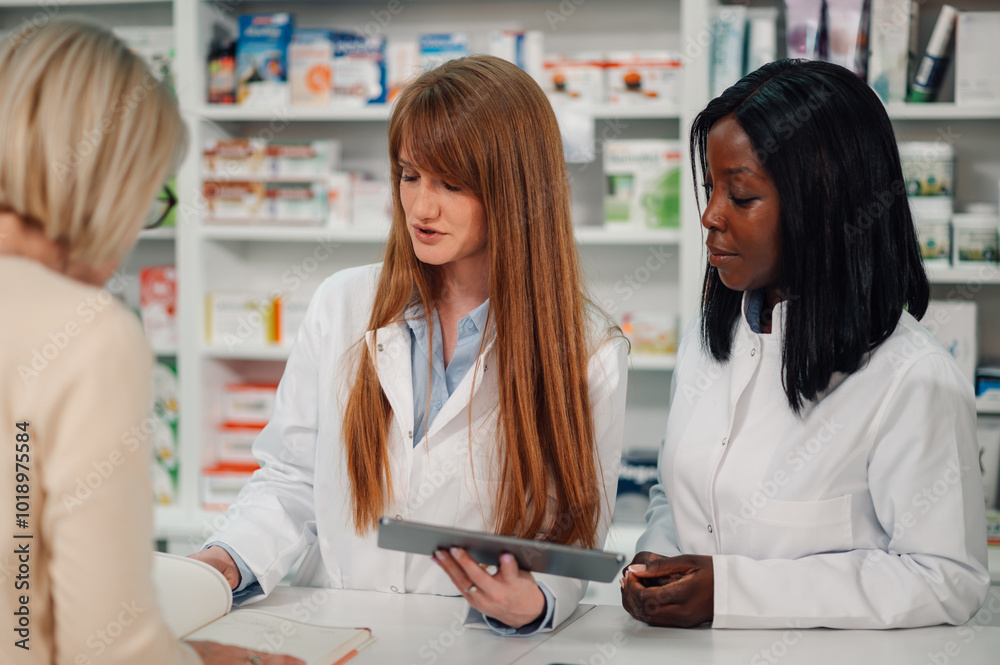 Diverse pharmacists with tablet having consultations with old woman. Diverse pharmacists with tablet having consultations with old woman.