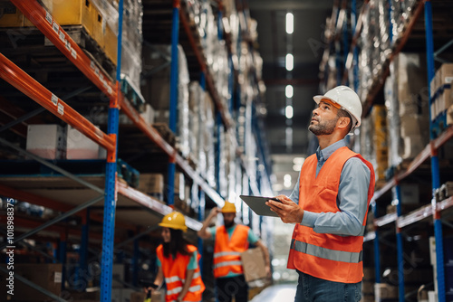 Warehouse manager using digital tablet checking inventory photo