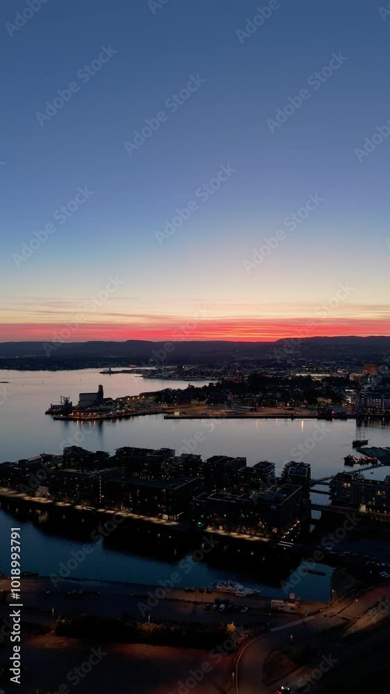 Oslo City Center and Oslo Fjord, Norway at Evening Twilight in Summer. Blue Hour. Aerial Drone Shot. Moving Backwards. Vertical Video Oslo City Center and Oslo Fjord, Norway at Evening Twilight in Summer. Blue Hour. Aerial Drone Shot. Moving Backwards. Vertical Video
