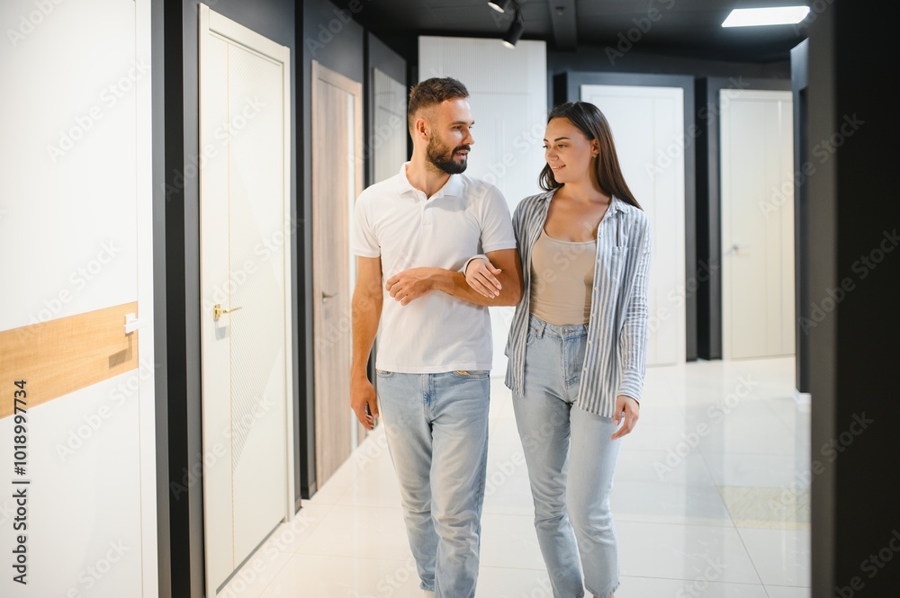 A young couple chooses interior doors for their new home. A young couple chooses interior doors for their new home.