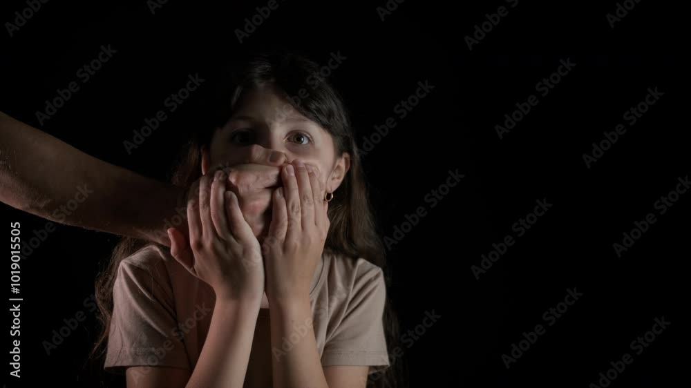 The man covers the child's mouth with his hand. A view of man put her palm on child mouth to stop speaking. A concept of interdiction or taboo during childhood. The man covers the child's mouth with his hand. A view of man put her palm on child mouth to stop speaking. A concept of interdiction or taboo during childhood.
