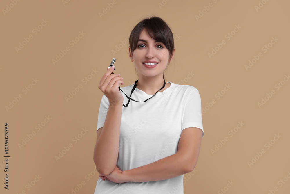 Happy woman with whistle on beige background Happy woman with whistle on beige background