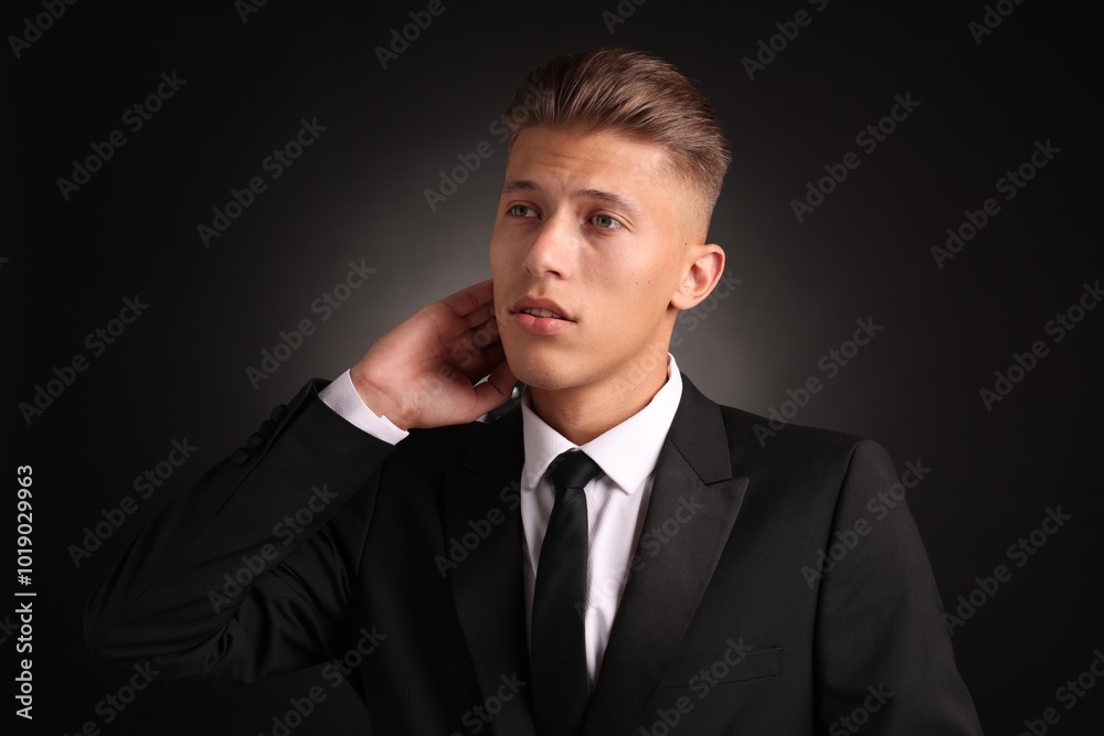 Confident young man with stylish haircut on black background Confident young man with stylish haircut on black background