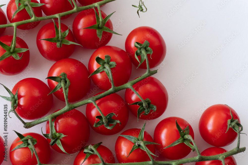 Ripe cherry tomatoes on branches against a white background for a plant-based diet. Fresh vegetables of natural origin. An excellent choice for vegetarians and organic product enthusiasts. Ripe cherry tomatoes on branches against a white background for a plant-based diet. Fresh vegetables of natural origin. An excellent choice for vegetarians and organic product enthusiasts.