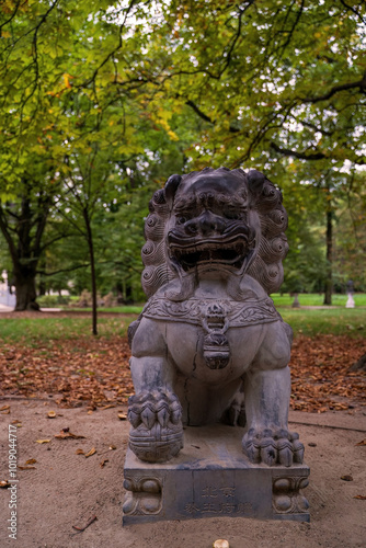 Obraz na płótnie Ancient Stone Lion Statue in Serene Park Setting w salonie