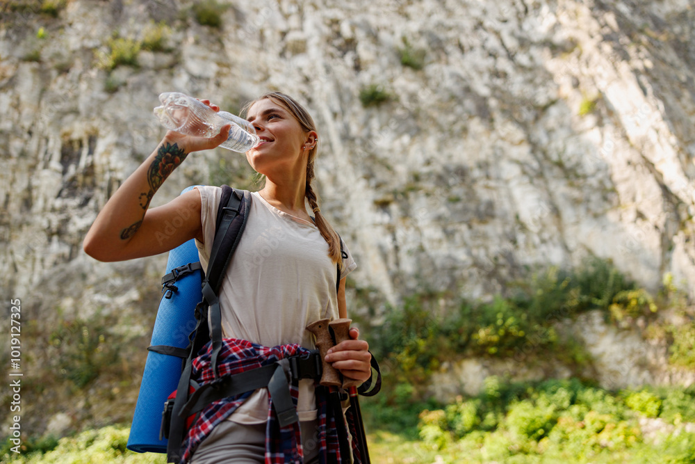 A Hiker is Enjoying a Refreshing Water Break while Surrounded by the Beautiful Nature A Hiker is Enjoying a Refreshing Water Break while Surrounded by the Beautiful Nature
