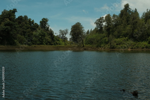 view of lake in indonesia with the bluish sky and the trees around the water, east java photo