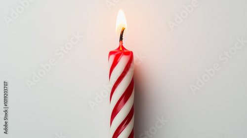 birthday candle concept image: red and white striped candle, top down view, a single birthday candle placed in the center of a white background