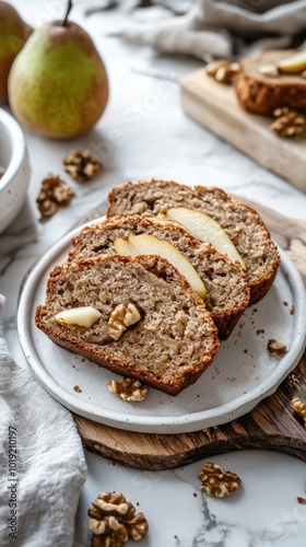 Vertical format, Deliciously baked pear and walnut bread served on a white plate with fresh pears in the background