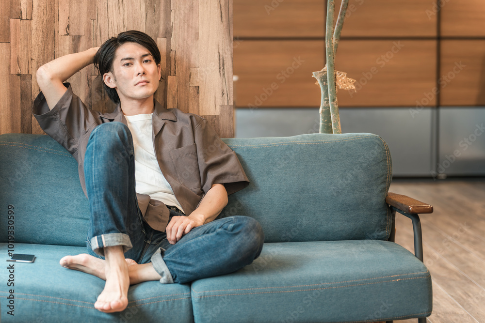 Obraz premium 家のリビングで退屈な時間を過ごす若いアジア人男性（つまらない・憂鬱・無気力・ダルい・疲労・鬱病） 
