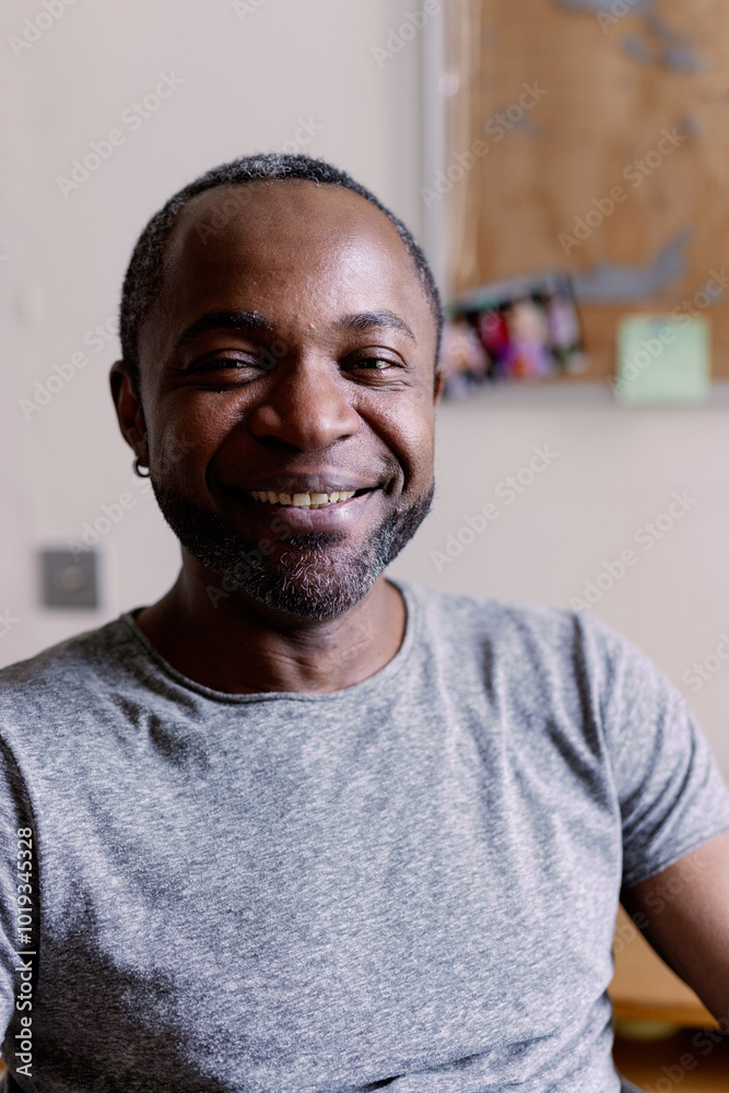 Portrait of smiling adult black man looking at camera in blurred room Portrait of smiling adult black man looking at camera in blurred room