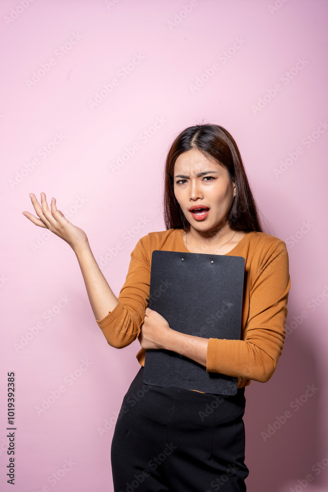 Fototapeta premium A woman in a business suit holding a clipboard with a black cover