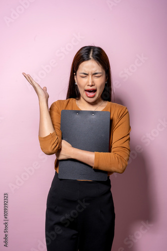 A woman is holding a clipboard and looking at it with a confused expression