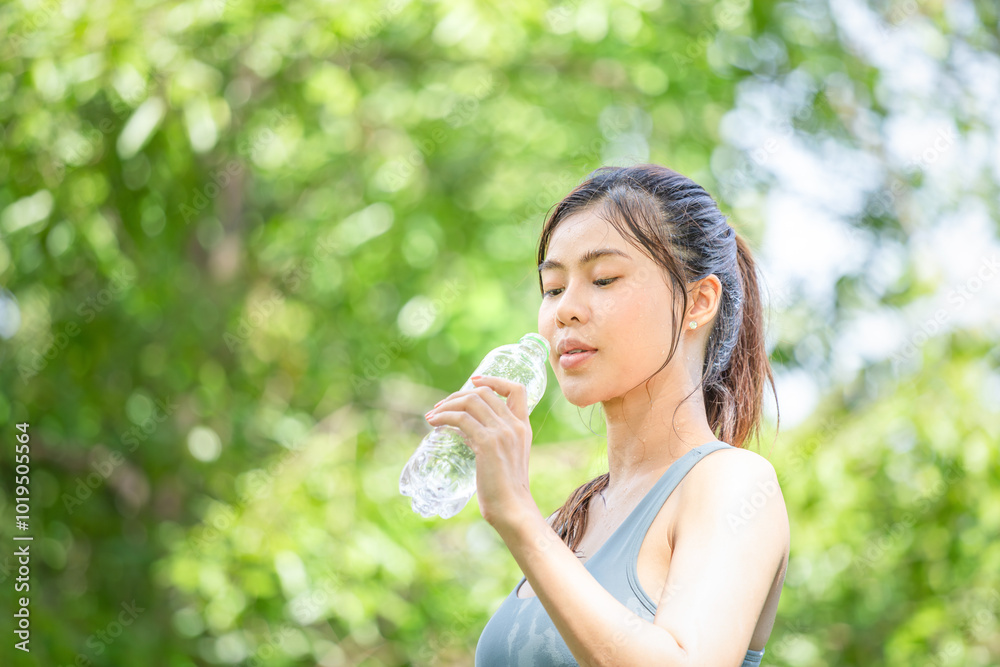 Athlete young beautiful woman drinking water from a plastic bottle at summer green park, Sport woman drinking water after work out exercising Athlete young beautiful woman drinking water from a plastic bottle at summer green park, Sport woman drinking water after work out exercising