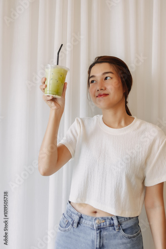 Happy healthy Asian woman drinking Iced Latte Matcha Green Tea.