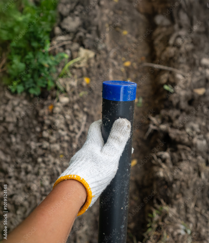 Obraz premium Pipe contractor install new HDPE pipes under the ground in village,