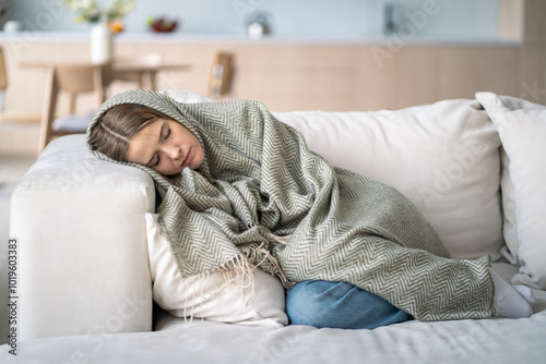 Konstfotografi Exhausted, lost woman rests lifeless on couch wrapped in blanket, battling depression, frustration