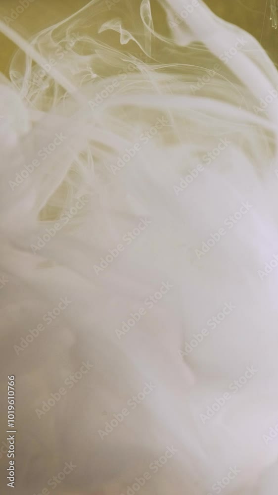 Vertical video. Ink water swirl. Creative smoke. Flow art. White vapor cloud silk fluid paint texture motion on blur yellow gold particles color abstract background. Vertical video. Ink water swirl. Creative smoke. Flow art. White vapor cloud silk fluid paint texture motion on blur yellow gold particles color abstract background.