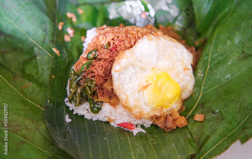 Indonesian Food Called Nasi Berkat, consisting of rice, egg, coconut, potatoes, and green chillies 