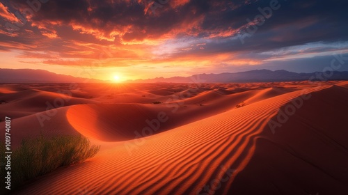 A stunning desert sunset with rippling sand dunes and vibrant clouds.