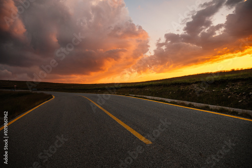 Sunset on Romania Transalpina road with many serpentines crossing forest in Carpathian mountains. Mountains forest trees with road in Parang mountains