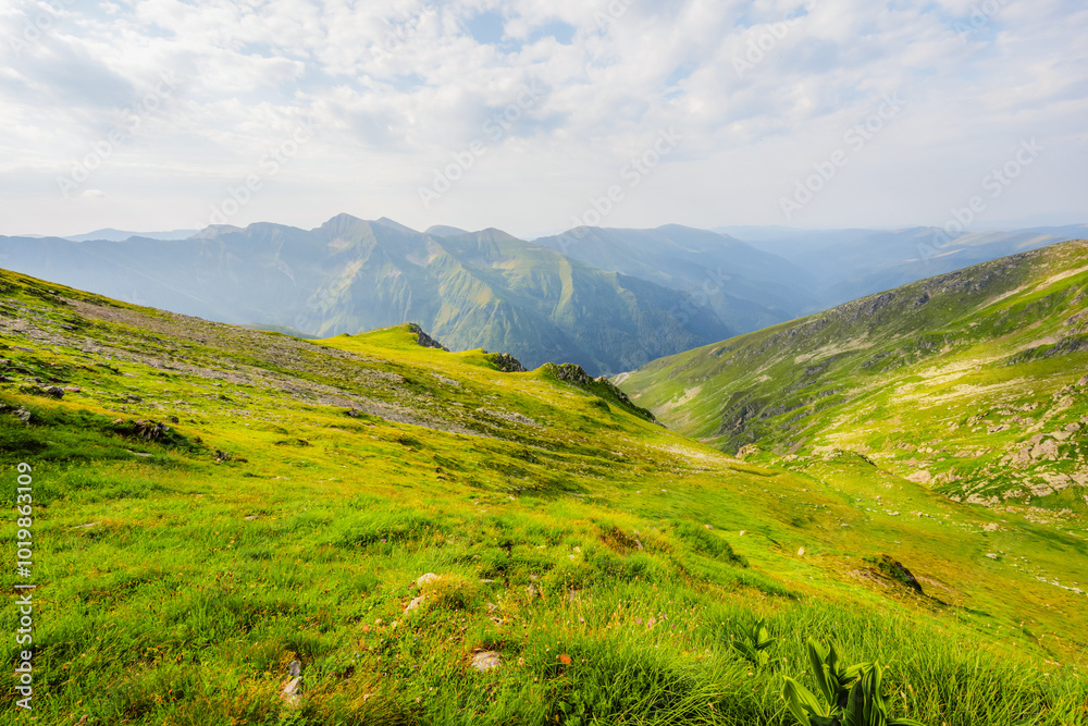 Hiking in Fagaras mountains on Iezerul Caprei peak over Transfagarasan serpentine road carpathian mountains. Mountains landscape Hiking in Fagaras mountains on Iezerul Caprei peak over Transfagarasan serpentine road carpathian mountains. Mountains landscape