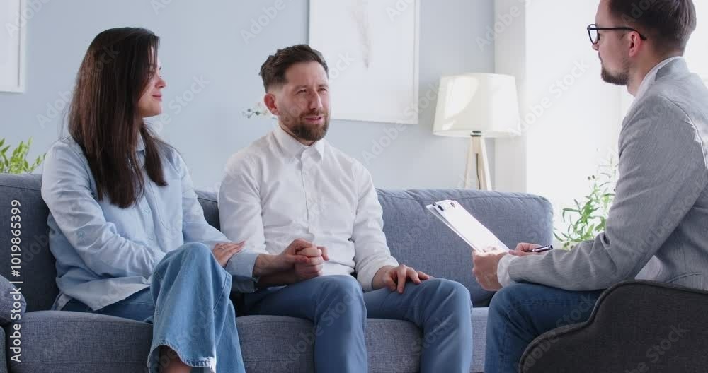 Family psychotherapy session, with a psychologist provides support and help to a family couple. They engage in a conversation, receiving advice and guidance to improve relationship and mental health. Family psychotherapy session, with a psychologist provides support and help to a family couple. They engage in a conversation, receiving advice and guidance to improve relationship and mental health.