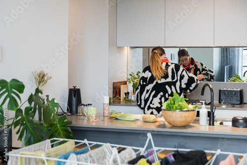 Person cooking in a cozy kitchen with a leafy plant in Melbourne photo