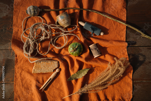 Rustic tools and crafts arranged on vibrant orange fabric photo