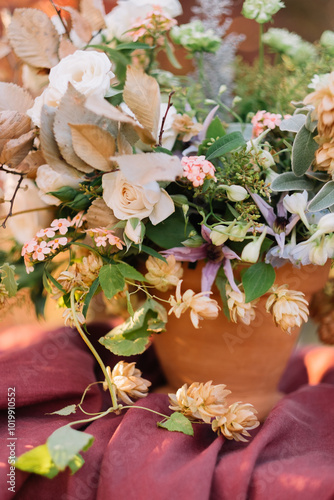 Elegant flower arrangement in terracotta pot indoors. photo