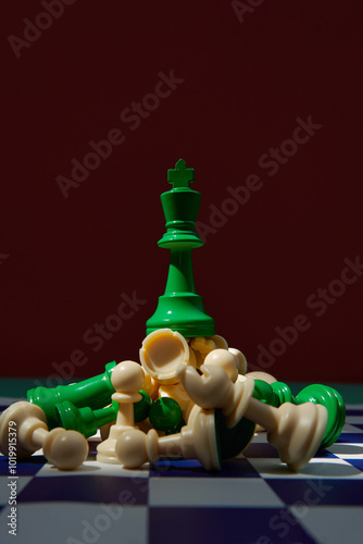 green king surrounded with beige chess pieces on chess board photo