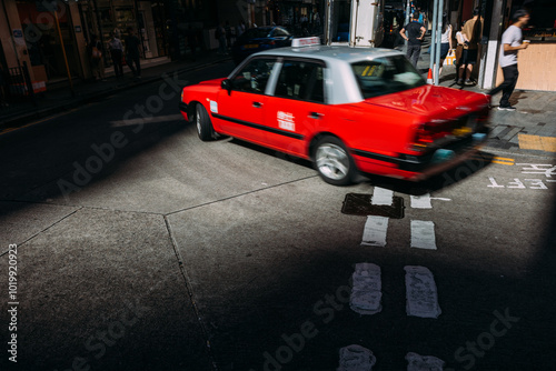 Red Taxi Turning on a Busy Urban Street