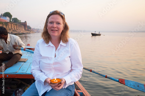 Woman Holding Diyas Candle on Boat at Ganges River During Sunrise photo