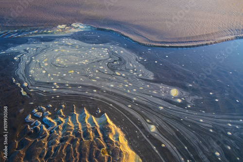 Tide pool of swirling, foamy water at dusk