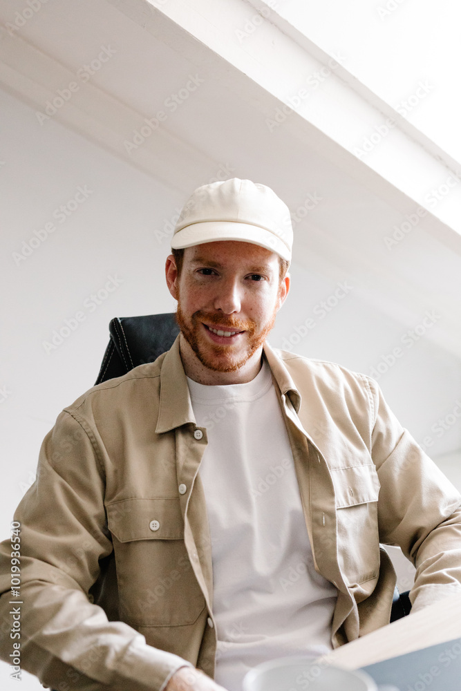 Portrait of a smiling publicist looking at the camera in his office Portrait of a smiling publicist looking at the camera in his office