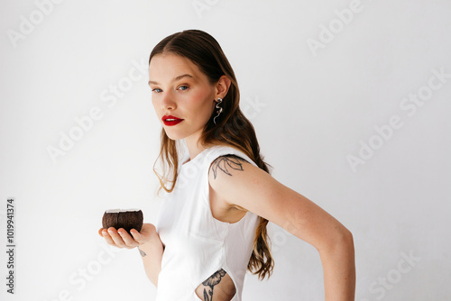 Woman sitting with ceramic coconut halves on chair photo