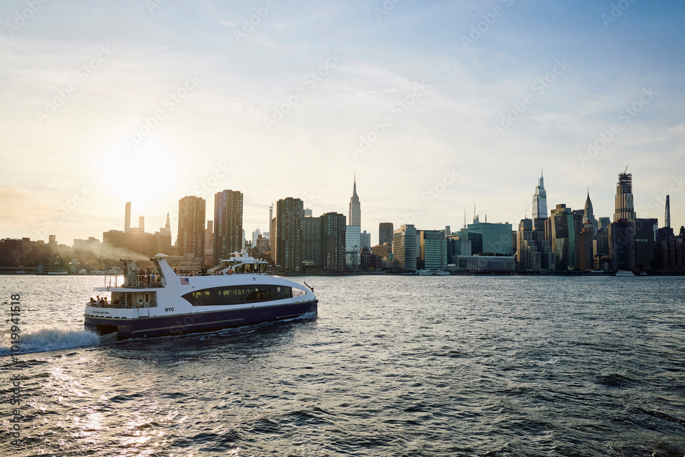 Ferry boat sails past the shoreline of New York City Ferry boat sails past the shoreline of New York City