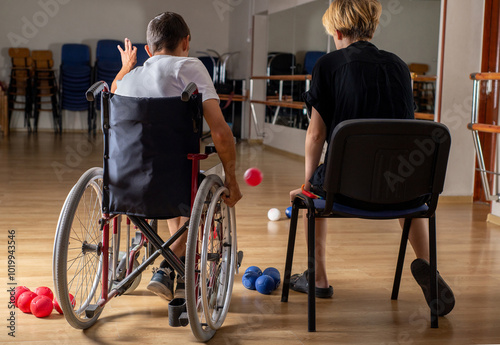 Faceless Paralympic athlete throws ball during boccia training photo