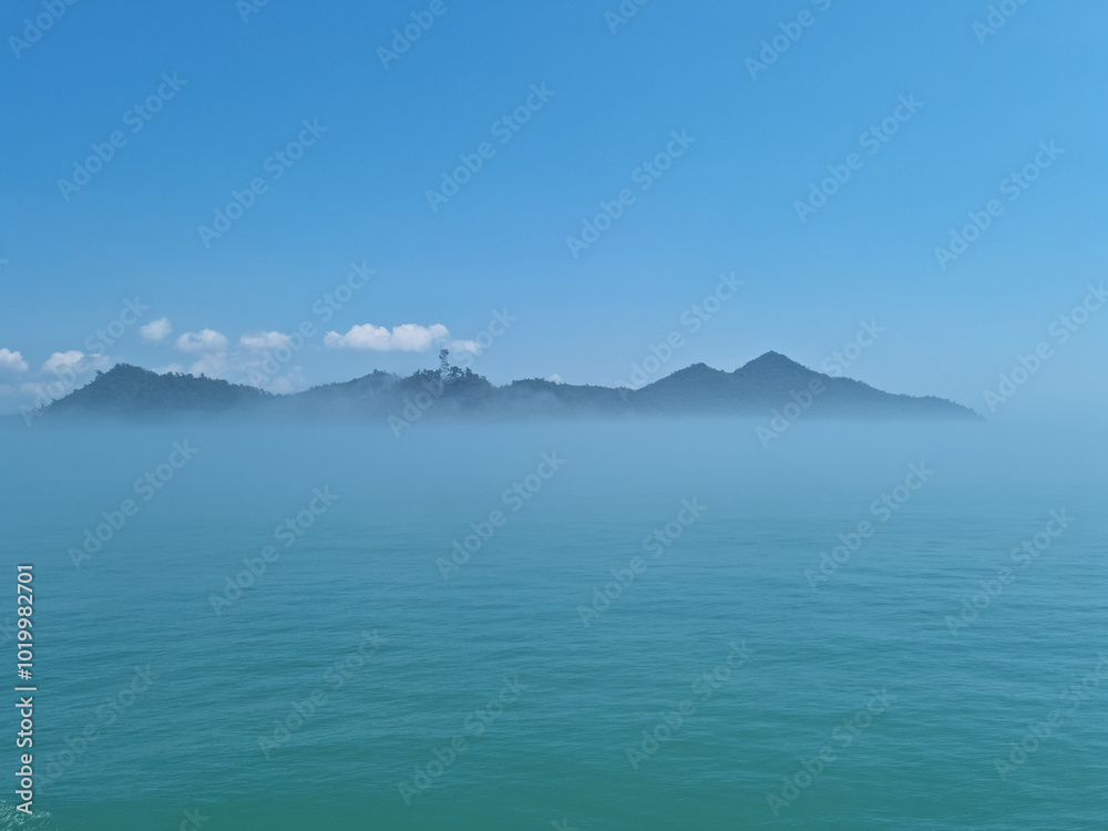It is a foggy sea and island. It is a foggy sea and island.
