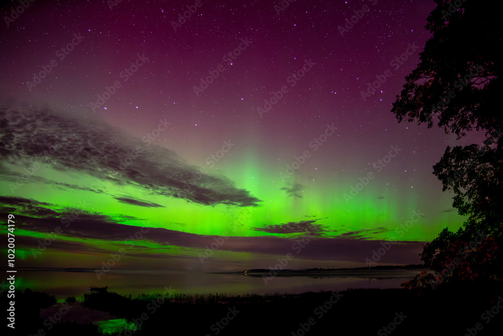 reflection of the northern lights in the lake on a cloudy autumn night reflection of the northern lights in the lake on a cloudy autumn night