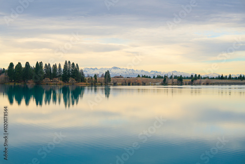 A breathtaking sunset over Lake Ruataniwha with golden reflections on the water and nearby mountains. This peaceful scene captures the beauty of New Zealand’s natural landscapes. photo