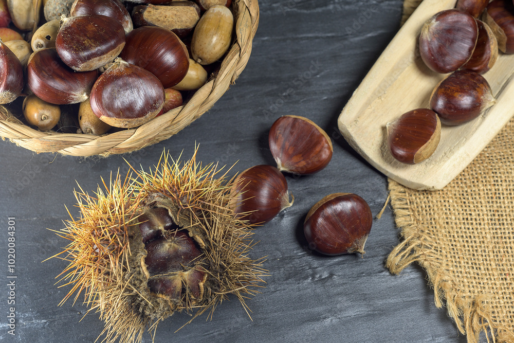 Chestnuts and autumn leaves on black background Chestnuts and autumn leaves on black background