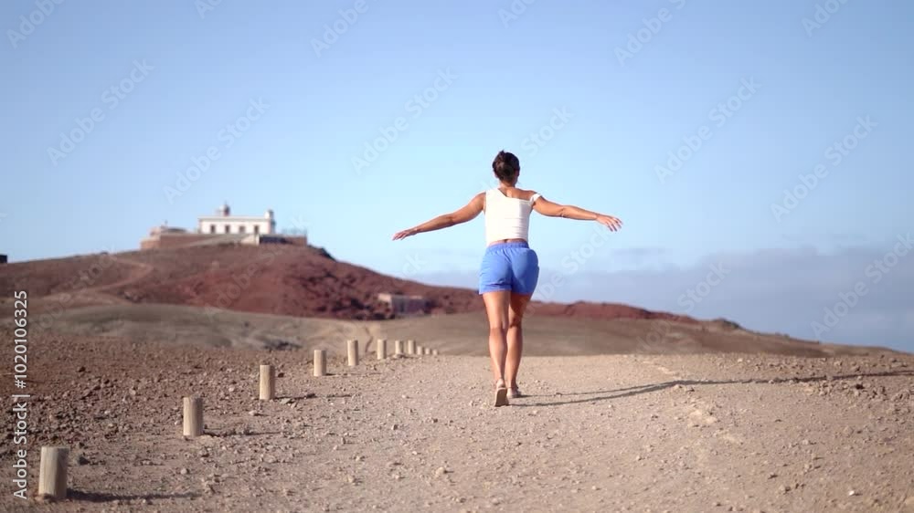 Tourist woman on holidays walking toward a lighthouse at mountain top in Gran Canaria, Spain. Tourist woman on holidays walking toward a lighthouse at mountain top in Gran Canaria, Spain.