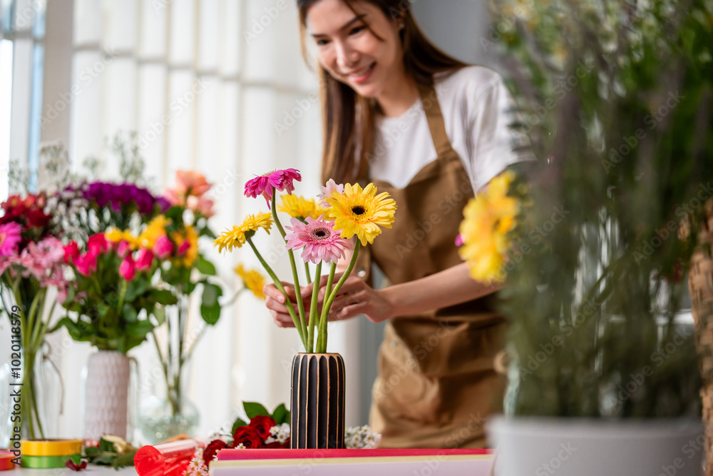Asian young florist girl completing beautiful bouquet in flower shop. Asian young florist girl completing beautiful bouquet in flower shop.