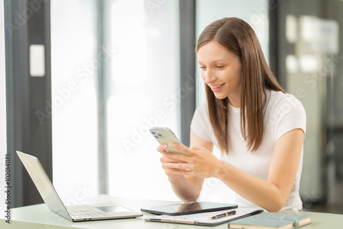 Beautiful young woman uses smartphone for business Online shopping, money transfers, internet banking, laptops, remote workers typing Send an email or research online.