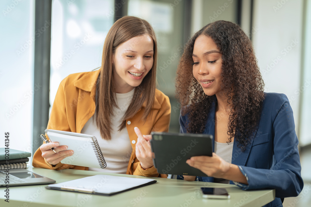 Two female colleagues discussing company business work using laptops and their emphatic expressions suggest that they are discussing important business matters. Two female colleagues discussing company business work using laptops and their emphatic expressions suggest that they are discussing important business matters.