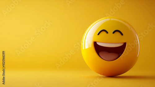 A laughing face emoji ball on a yellow background with copy space. Representing positive emotions like joy, happiness, or laughter.