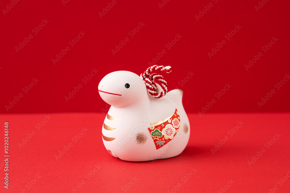Japanese new year material. Zodiac Snake. Snake ornament on the red background. 日本のお正月素材。干支の巳(ヘビ)。赤背景上の巳の置物 Japanese new year material. Zodiac Snake. Snake ornament on the red background. 日本のお正月素材。干支の巳(ヘビ)。赤背景上の巳の置物